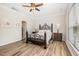 Bedroom with ceiling fan, wood-look flooring, and decorative metal framed bed with side tables at 3034 Raddercrest Ct, Fuquay Varina, NC 27526