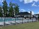 Community pool with surrounding lounge chairs and a clubhouse, great for relaxation and recreation at 3034 Raddercrest Ct, Fuquay Varina, NC 27526