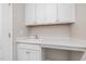 A laundry room with white cabinets, white countertops, a sink, and under counter space at 3034 Raddercrest Ct, Fuquay Varina, NC 27526