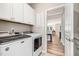 Bright laundry room featuring white cabinets, modern washer and dryer, plus doorway to office area at 3034 Raddercrest Ct, Fuquay Varina, NC 27526