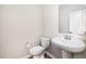 Clean half bathroom with white toilet, white pedestal sink, and a modern mirror at 3034 Raddercrest Ct, Fuquay Varina, NC 27526