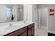 Well-lit bathroom featuring double sinks, stylish mirror, wood vanity, and separate doors for toilet and shower at 325 Avery Glenn Way, Fuquay Varina, NC 27526