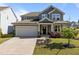 Charming two-story home featuring a gray facade, covered porch, two-car garage, and well-maintained landscaping at 325 Avery Glenn Way, Fuquay Varina, NC 27526