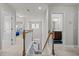 Upstairs hallway shows stairs, view of front door, bedroom, and bathroom with wood vanity at 325 Avery Glenn Way, Fuquay Varina, NC 27526
