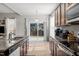Well-lit kitchen with granite countertops and stainless steel appliances, showcasing backyard access for easy outdoor entertaining at 325 Avery Glenn Way, Fuquay Varina, NC 27526
