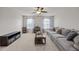 Relaxing living room with gray sofa, ceiling fan, decorative shelving, and glass coffee table at 325 Avery Glenn Way, Fuquay Varina, NC 27526