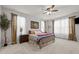 Comfortable primary bedroom with ceiling fan, soft carpet, and decorative painting above the bed at 325 Avery Glenn Way, Fuquay Varina, NC 27526