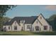 Charming two-story home featuring light brick, a dark roof, and manicured landscaping at 33 Versailles Ln, Pittsboro, NC 27312