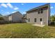 The backyard features lush green grass, gray vinyl siding, a white back door, and a black metal fence at 3816 Mike Levi Ct, Raleigh, NC 27610