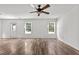 Open-concept living room showcasing luxury vinyl plank flooring, windows, and a white entry door at 3816 Mike Levi Ct, Raleigh, NC 27610