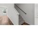 Bright stairway with neutral carpet, wood railing, and a window at the landing at 3816 Mike Levi Ct, Raleigh, NC 27610