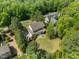 An aerial view shows a spacious backyard patio with outdoor seating surrounded by mature trees at 3913 Orchard Point Ct, Apex, NC 27539