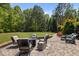 A backyard patio with stone pavers and comfortable outdoor seating surrounded by lush green landscaping at 3913 Orchard Point Ct, Apex, NC 27539