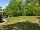 Expansive backyard showing large green lawn and treeline provides privacy and space for outdoor activities at 3913 Orchard Point Ct, Apex, NC 27539