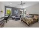 Bedroom featuring a seating area, desk, and large windows with wooded views at 3913 Orchard Point Ct, Apex, NC 27539