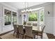 A dining area features large windows and a view of the landscaped backyard for elegant meals at 3913 Orchard Point Ct, Apex, NC 27539