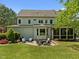 Exterior backyard elevation featuring a patio, screened-in porch, and lush landscaping at 3913 Orchard Point Ct, Apex, NC 27539