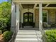 Elegant front entrance with a beautiful wood door, stone accents, and stylish lighting at 3913 Orchard Point Ct, Apex, NC 27539
