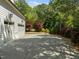 A three car garage sits on a large concrete driveway with beautiful trees and a basketball hoop nearby at 3913 Orchard Point Ct, Apex, NC 27539