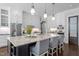 Large island in the kitchen is a central spot for cooking with stone counters and modern lighting at 3913 Orchard Point Ct, Apex, NC 27539