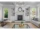 Cozy living room with fireplace, built-in bookshelves, and large windows, perfect for relaxation at 3913 Orchard Point Ct, Apex, NC 27539