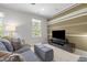 Living room features a striped accent wall, TV, gray couch and ottoman providing a modern look at 3913 Orchard Point Ct, Apex, NC 27539