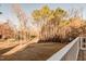 View of the backyard from a wooden deck with mature trees and natural landscaping at 4009 Yates Mill Pond Rd, Raleigh, NC 27606