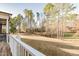 Spacious backyard surrounded by mature trees, view from the wooden deck with white railings at 4009 Yates Mill Pond Rd, Raleigh, NC 27606