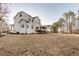 Large backyard with lush greenery and a white home featuring a screened porch at 4009 Yates Mill Pond Rd, Raleigh, NC 27606