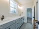 Elegant bathroom featuring a gray vanity with double sinks, a window, and stylish hexagon tile flooring at 4009 Yates Mill Pond Rd, Raleigh, NC 27606