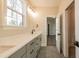 Bathroom featuring gray cabinets, dual sinks, quartz countertop, modern fixtures, and large format tile floors at 4009 Yates Mill Pond Rd, Raleigh, NC 27606