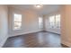 Bright bedroom featuring hardwood floors, three windows providing ample natural light, and neutral wall paint at 4009 Yates Mill Pond Rd, Raleigh, NC 27606