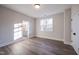 Bedroom featuring wood floors, a window, and a door leading to a bathroom at 4009 Yates Mill Pond Rd, Raleigh, NC 27606