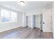 Bedroom featuring wood floors, a large window, and two closet doors at 4009 Yates Mill Pond Rd, Raleigh, NC 27606