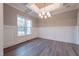 Spacious dining room featuring hardwood floors, modern chandelier, and large windows at 4009 Yates Mill Pond Rd, Raleigh, NC 27606