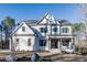 Inviting two-story white home with a charming front porch, manicured lawn, and professional landscaping at 4009 Yates Mill Pond Rd, Raleigh, NC 27606