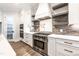 Gourmet kitchen with stainless steel range, pot filler, modern backsplash, and custom cabinetry at 4009 Yates Mill Pond Rd, Raleigh, NC 27606