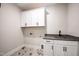 Laundry room featuring white cabinets and a stainless steel sink at 4009 Yates Mill Pond Rd, Raleigh, NC 27606