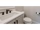 Stylish powder room featuring marble countertop, black hardware, and modern toilet at 4009 Yates Mill Pond Rd, Raleigh, NC 27606