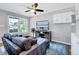 Cozy living room with large windows, modern furnishings, and a ceiling fan at 4114 Sudbury Rd, Durham, NC 27704