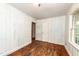 Comfortable bedroom offers hardwood floors, wood paneling, a closet, and a window view at 420 Peyton St, Raleigh, NC 27610
