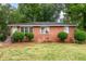 Charming brick home with manicured landscaping, lush trees, and updated windows at 420 Peyton St, Raleigh, NC 27610