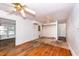 A living room with hardwood floors, a ceiling fan, and access to another room through an open doorway at 420 Peyton St, Raleigh, NC 27610