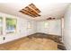 A bright sun room with lots of windows and a white painted brick wall, needing repairs to the ceiling at 420 Peyton St, Raleigh, NC 27610