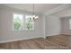 Elegant dining area featuring a modern chandelier, large windows, and hardwood floors, perfect for entertaining at 452 Golden Dragonfly St, Wake Forest, NC 27587
