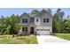 Inviting two-story home with a charming front porch and an attached two-car garage, surrounded by mature trees at 452 Golden Dragonfly St, Wake Forest, NC 27587