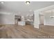 Open-concept living space featuring hardwood floors, a modern kitchen, and elegant lighting fixtures at 452 Golden Dragonfly St, Wake Forest, NC 27587