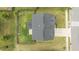 Overhead view of a home with a well-maintained roof, long driveway, green lawn and surrounding landscaping at 4718 Sleepy Falls Run, Knightdale, NC 27545