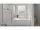 Clean, neutral bathroom with separate shower and soaking tub, and frosted window for natural light and privacy at 4718 Sleepy Falls Run, Knightdale, NC 27545