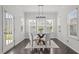 Bright breakfast nook with modern light fixture, round glass table, and lots of natural light from surrounding windows at 4718 Sleepy Falls Run, Knightdale, NC 27545